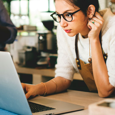 woman wearing apron with laptop